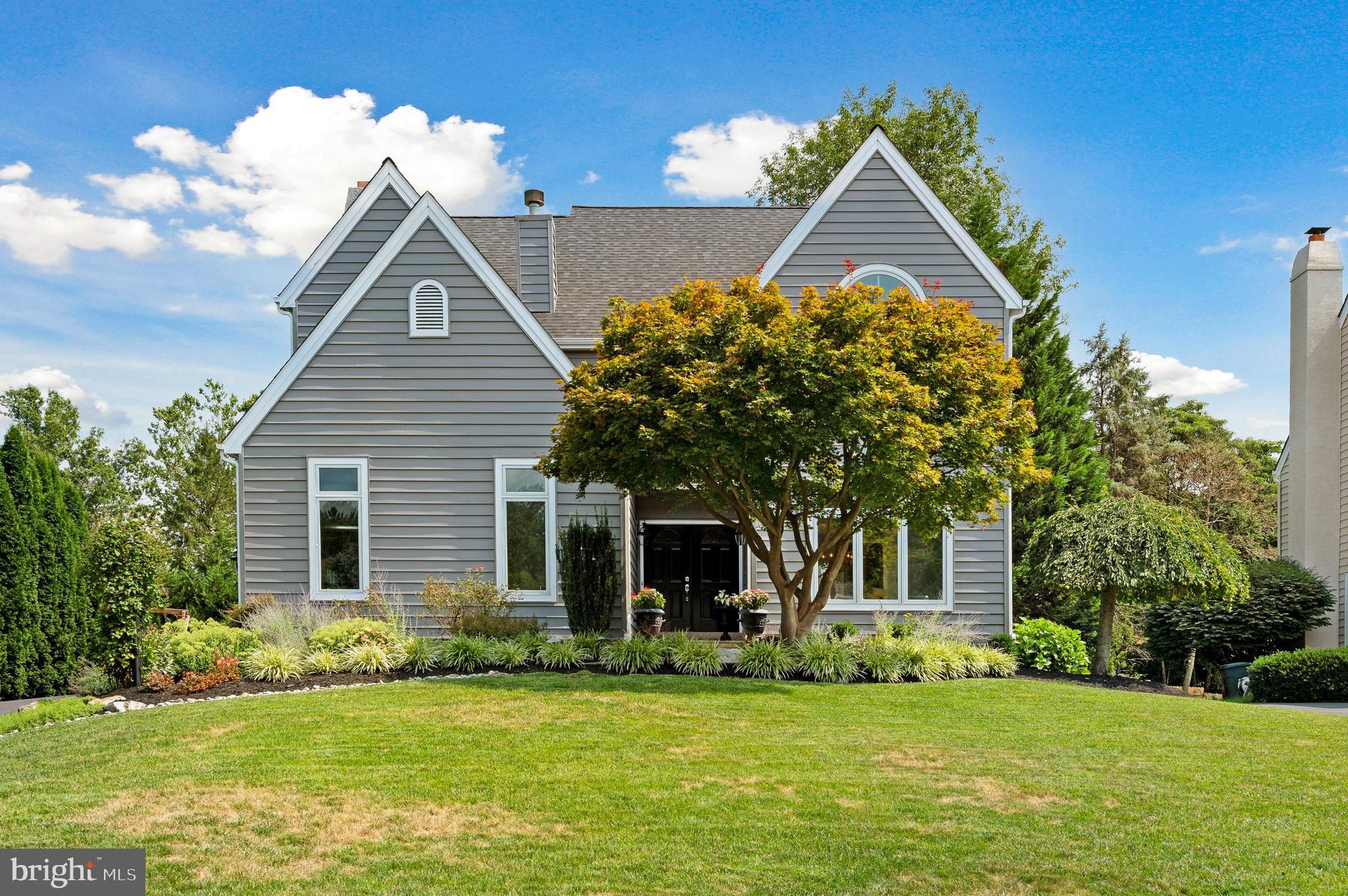 a front view of a house with a garden and yard