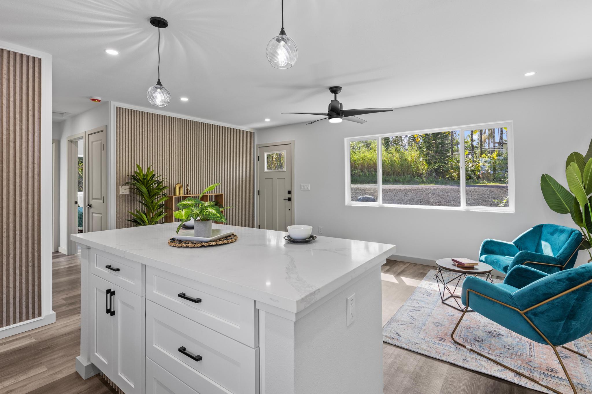 a view of kitchen island with stainless steel appliances granite countertop furniture and a chandelier