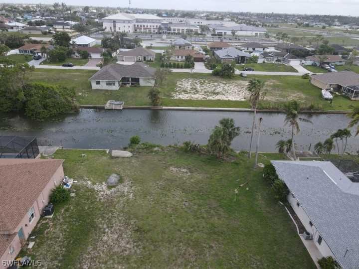 an aerial view of residential houses with outdoor space and lake view