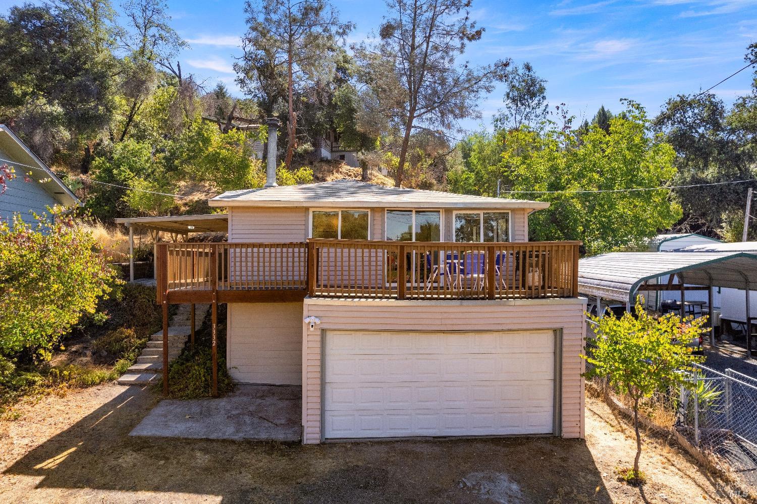 an aerial view of a house with large trees and a yard