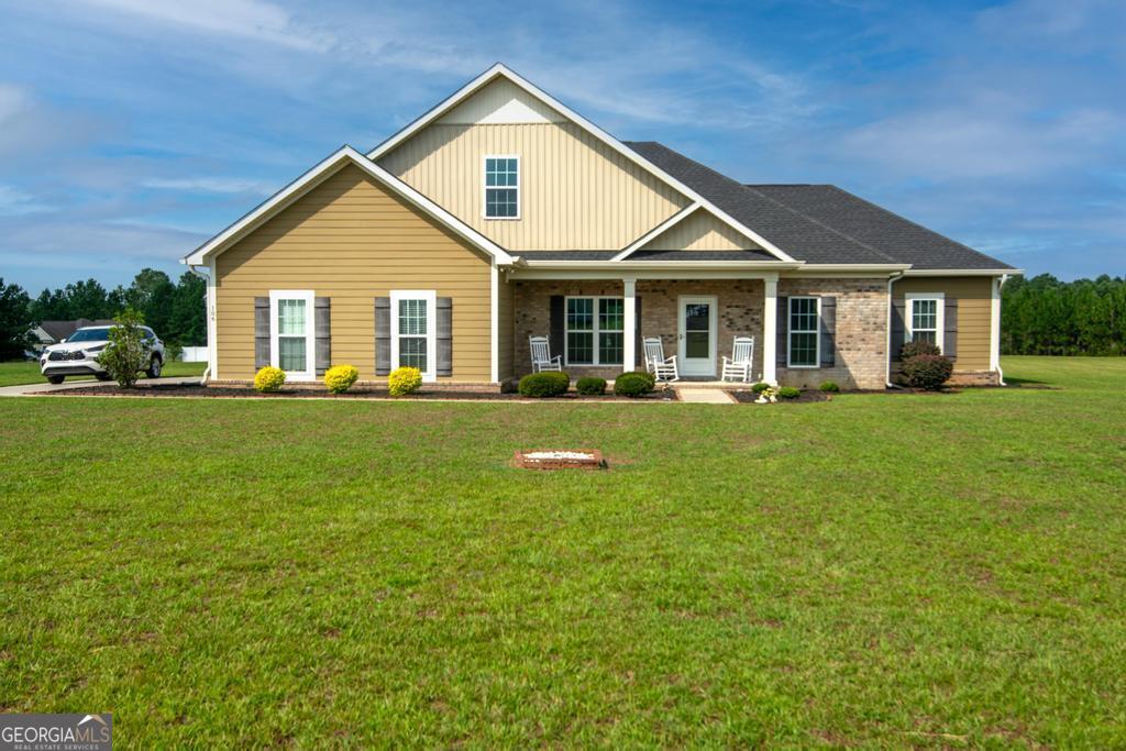 a front view of a house with a yard and trees