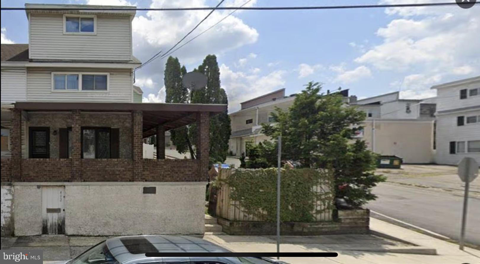 a view of a house with a cars park side of road