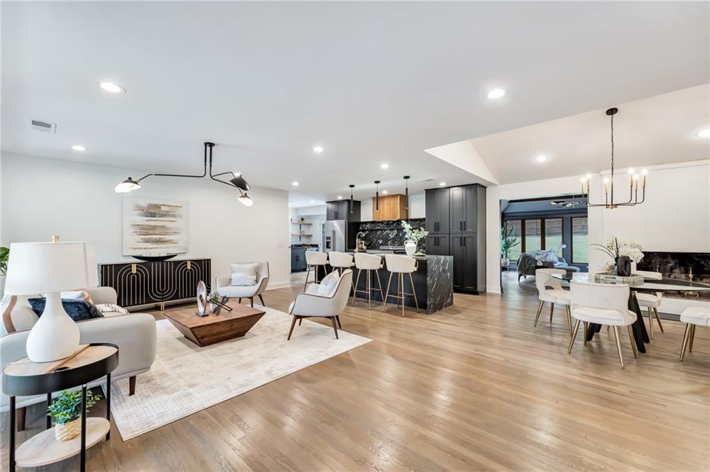 a living room with furniture kitchen view and a wooden floor