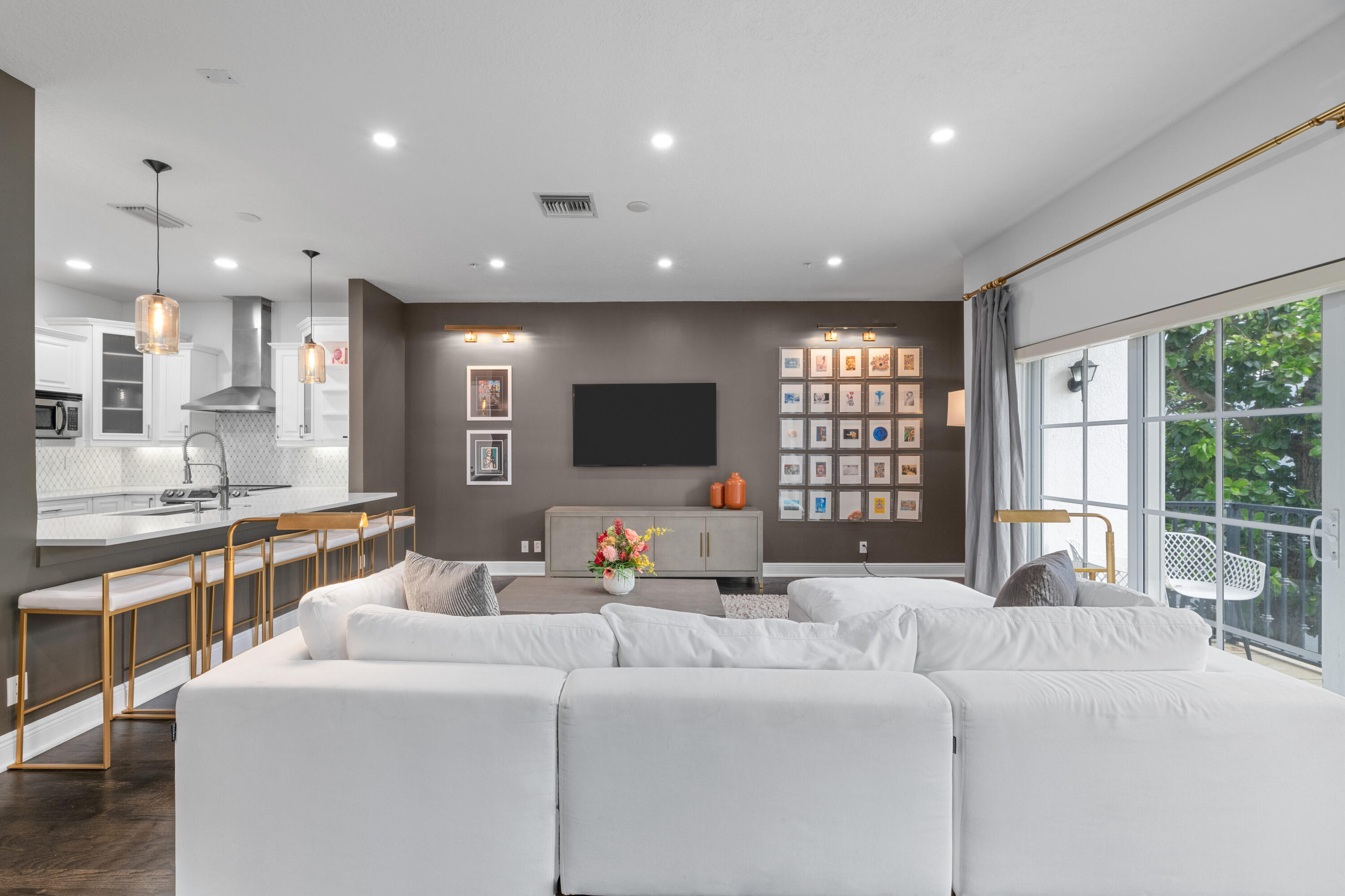 a living room with furniture a flat screen tv and a large window