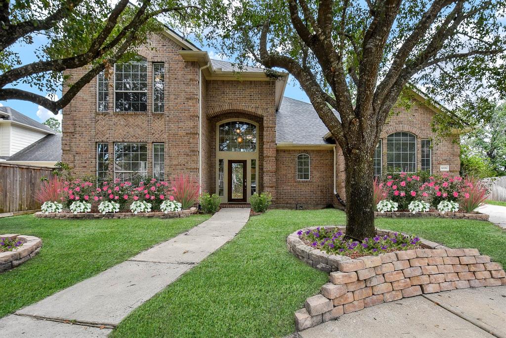 a front view of a house with a yard and potted plants