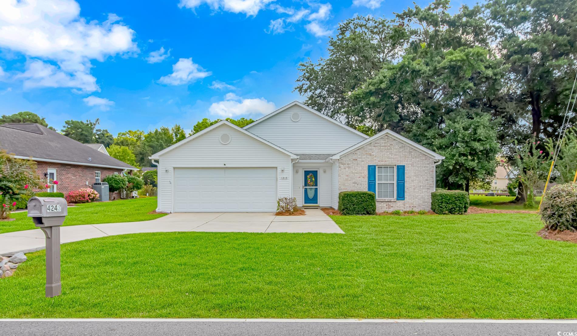 Ranch-style home featuring a front yard and a gara