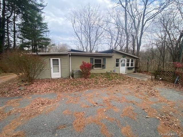 a front view of house with yard and trees around