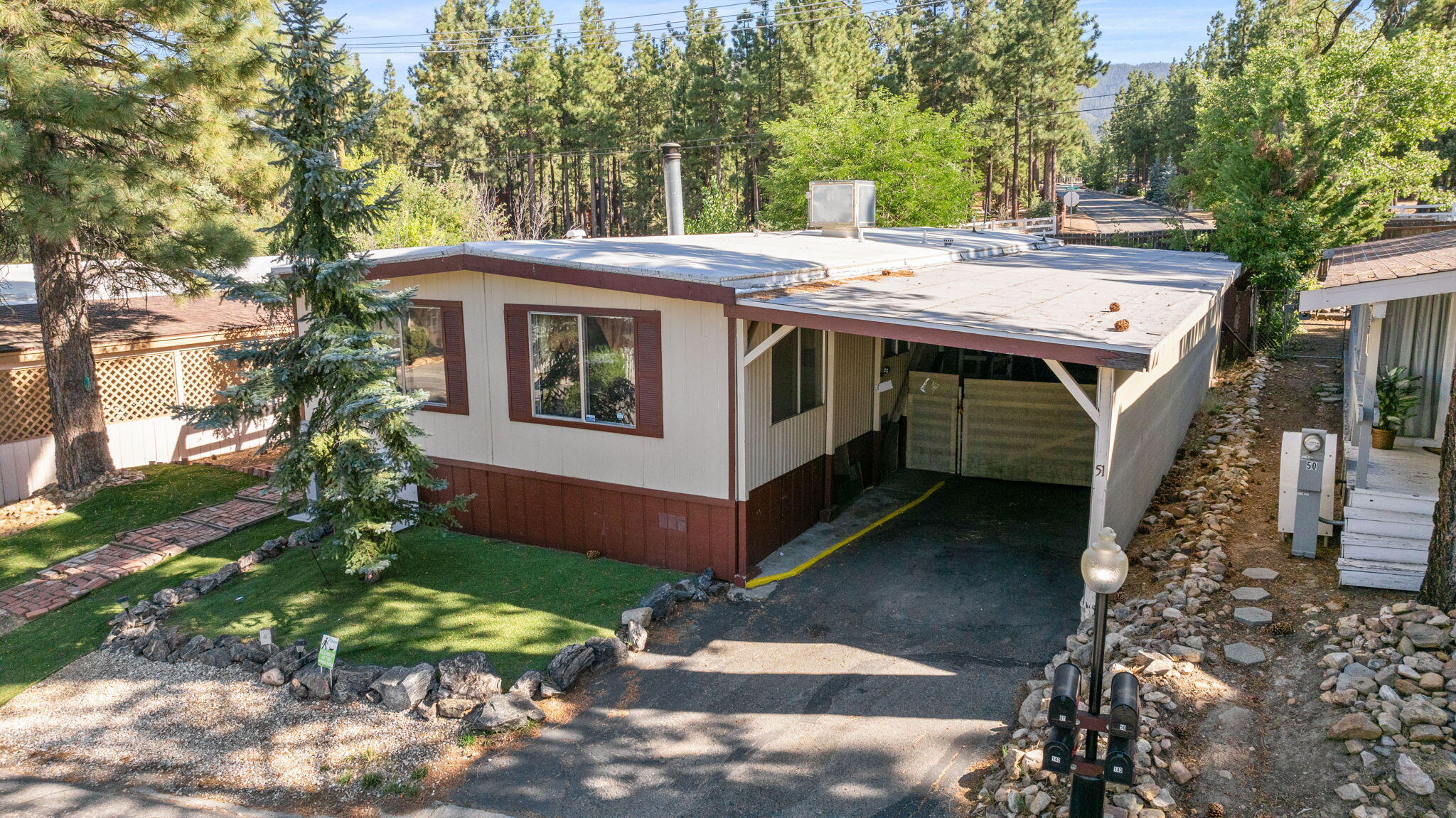 a view of a house with a yard and large trees