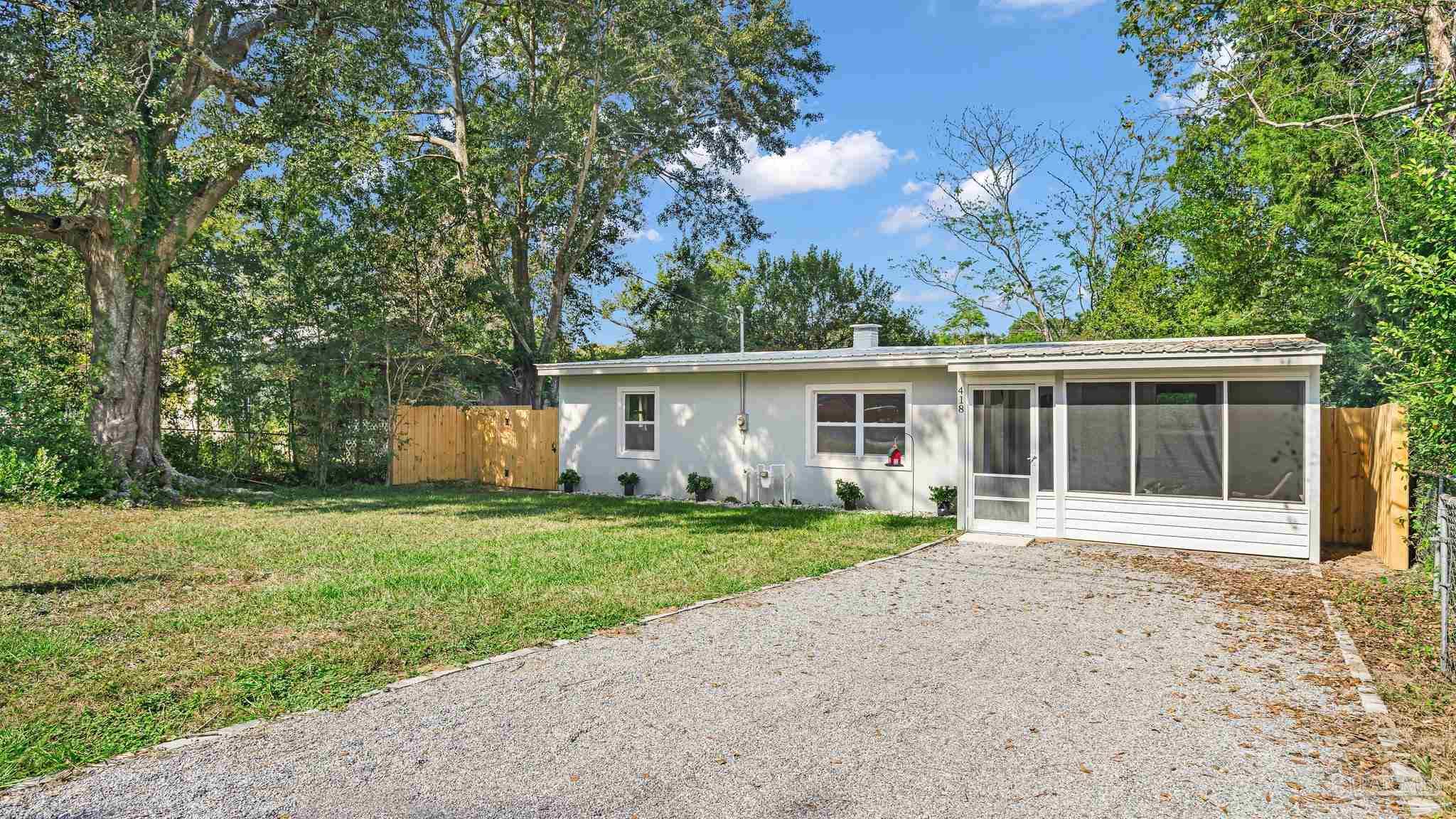 a front view of a house with a yard and trees