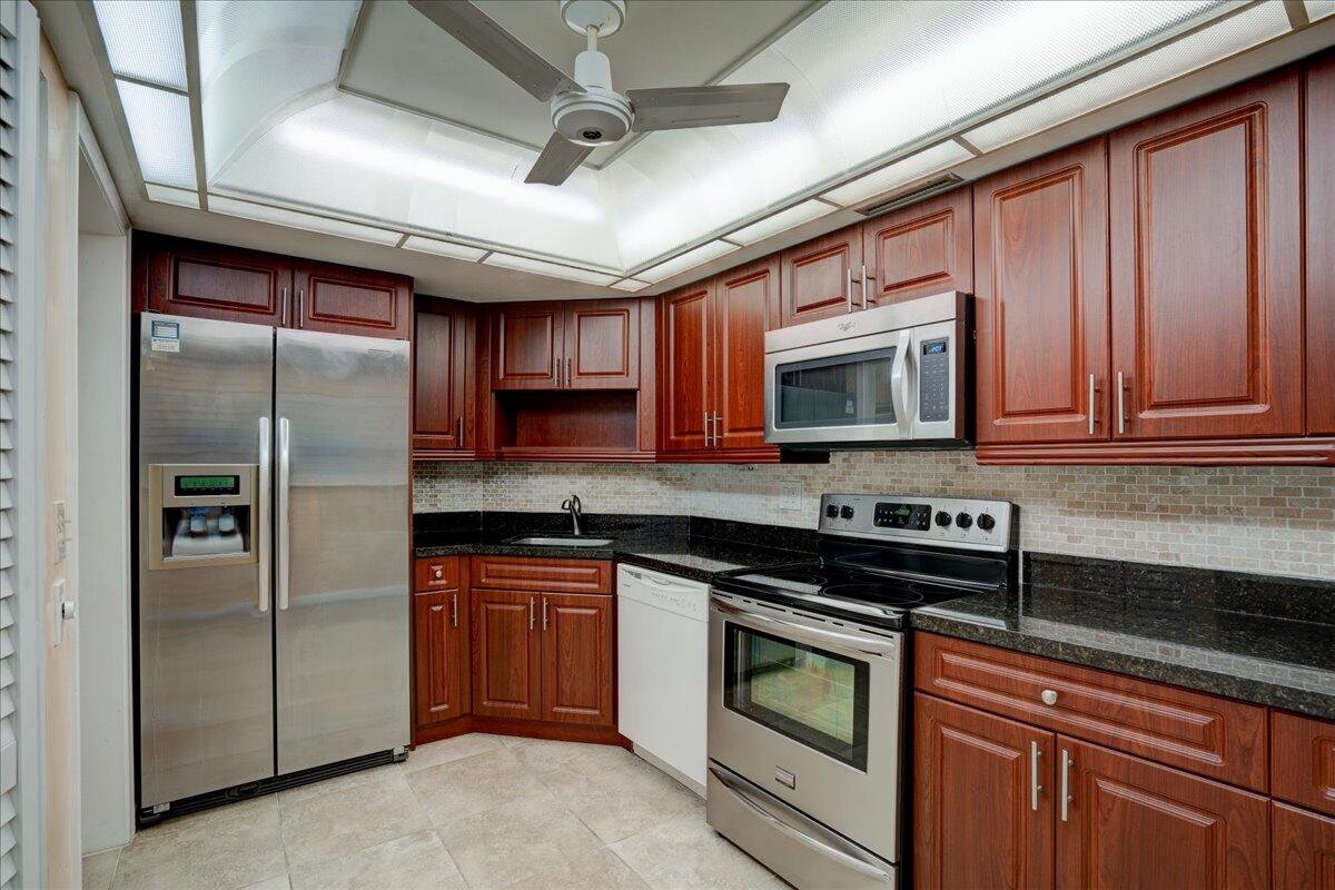 a kitchen with stainless steel appliances granite countertop a stove microwave and refrigerator