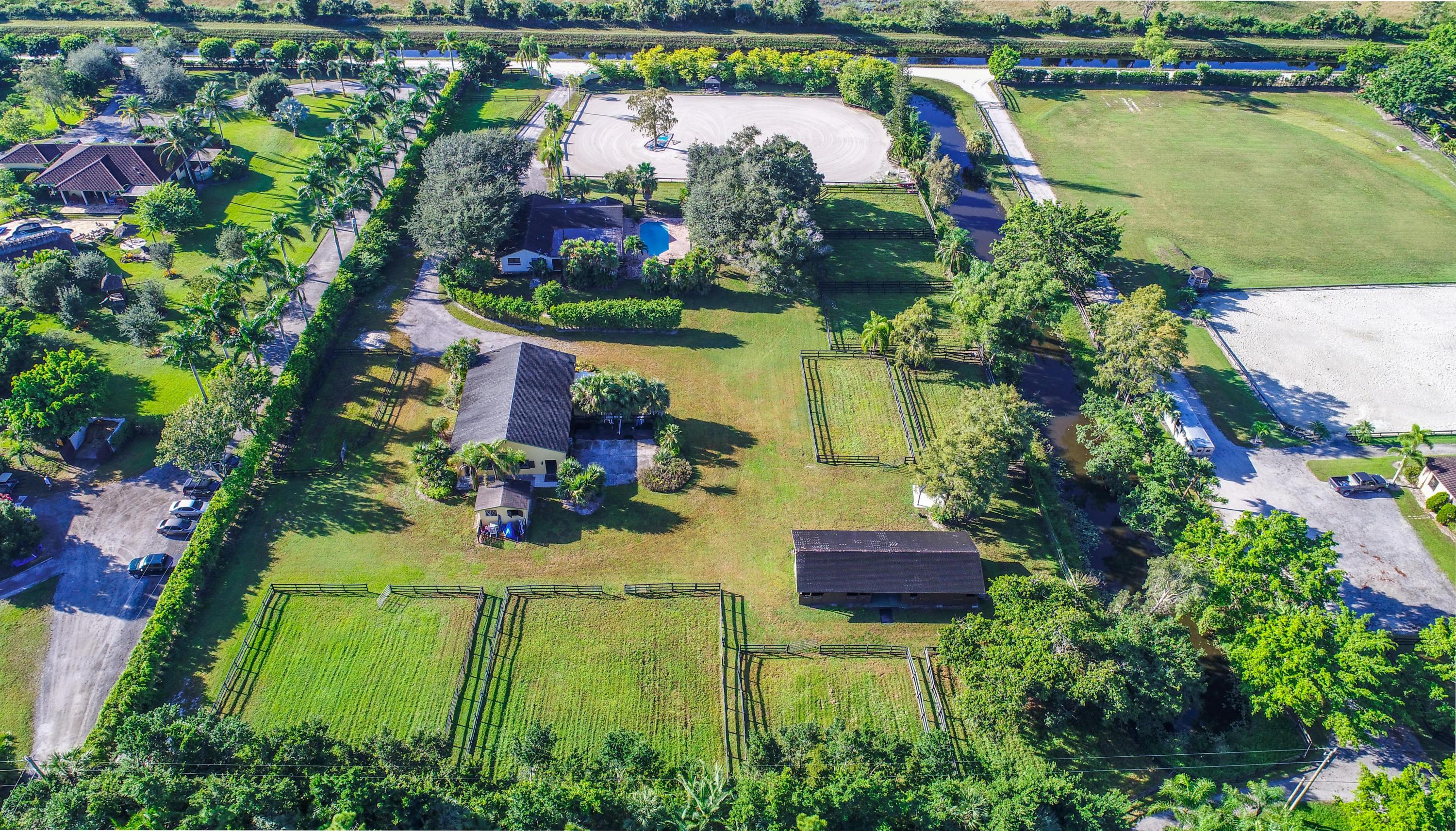 an aerial view of a house with a garden and lake view