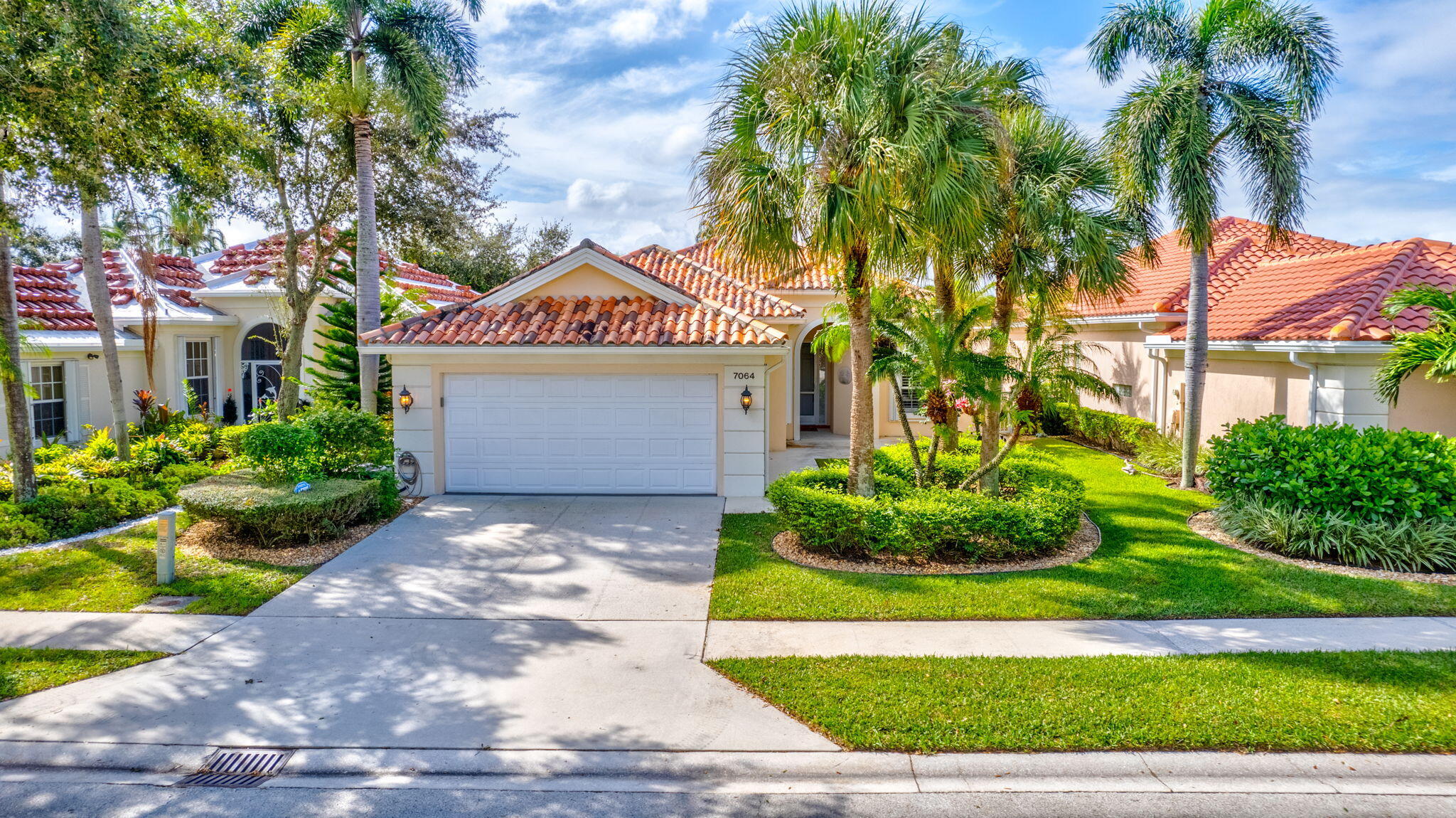 a front view of a house with a yard and potted plants