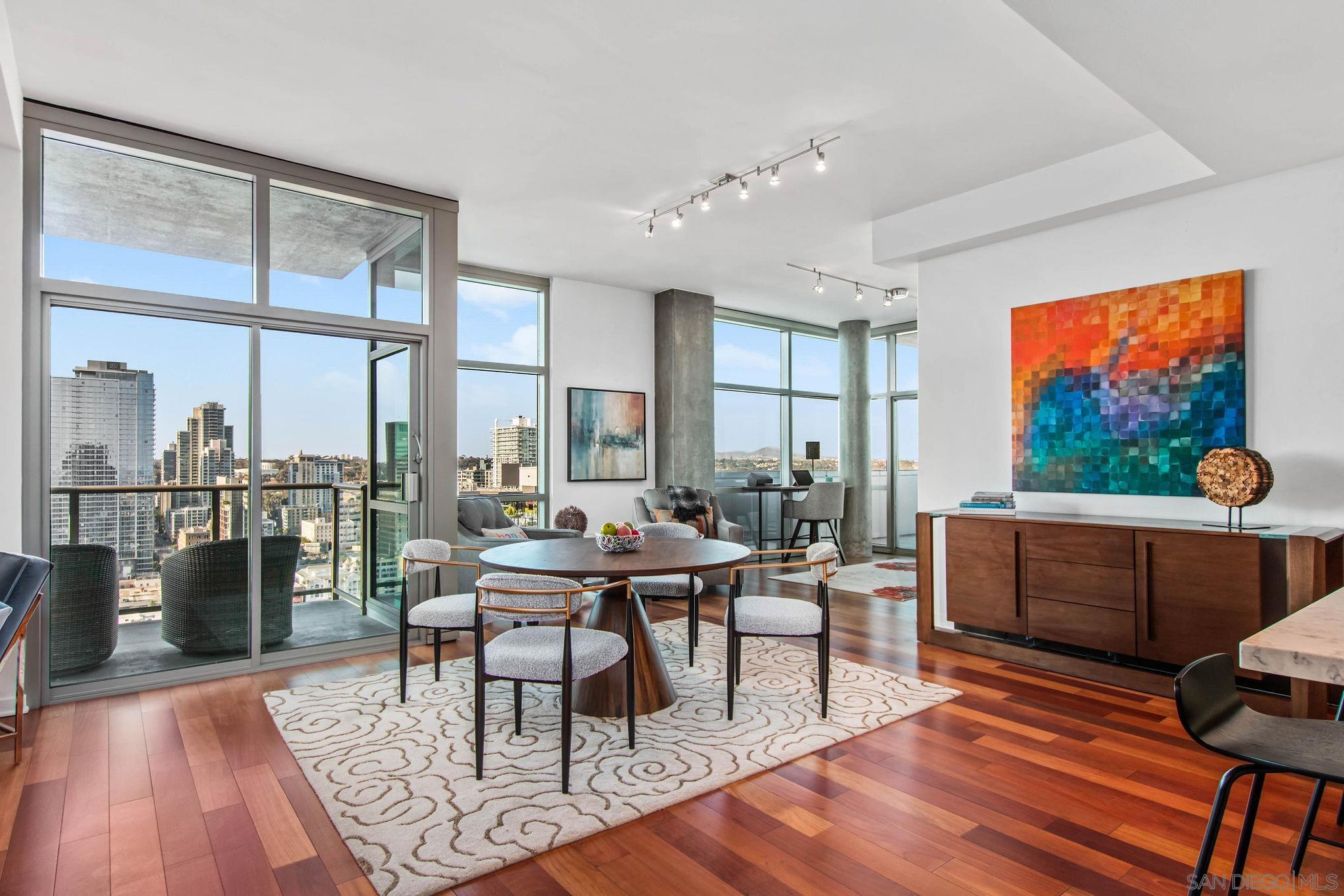 a living room with furniture a rug potted plant and a large window