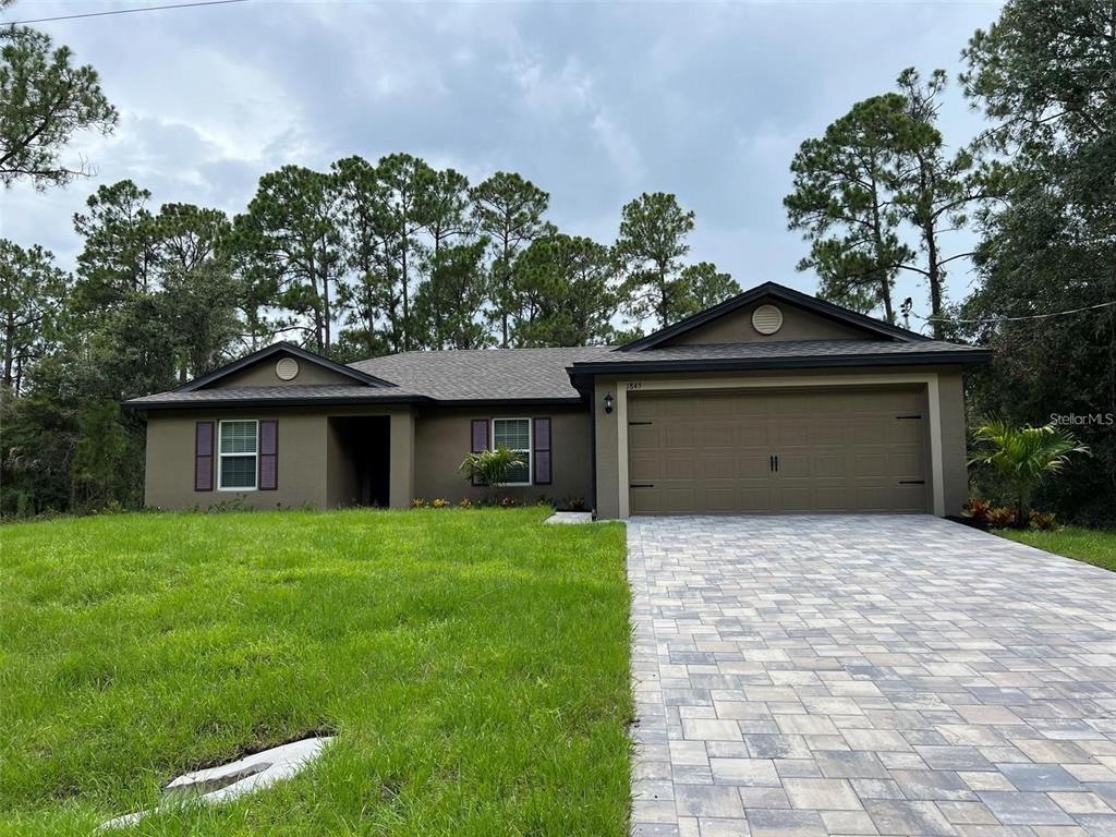 a front view of a house with a yard and garage