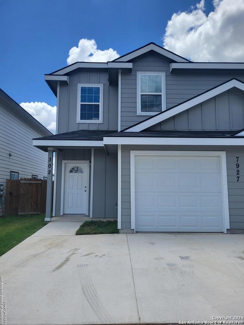 a view of a house with a yard and garage