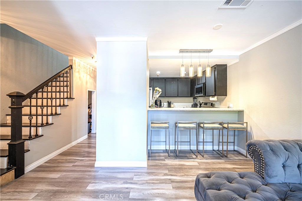 a living room with furniture with kitchen view and a dining table