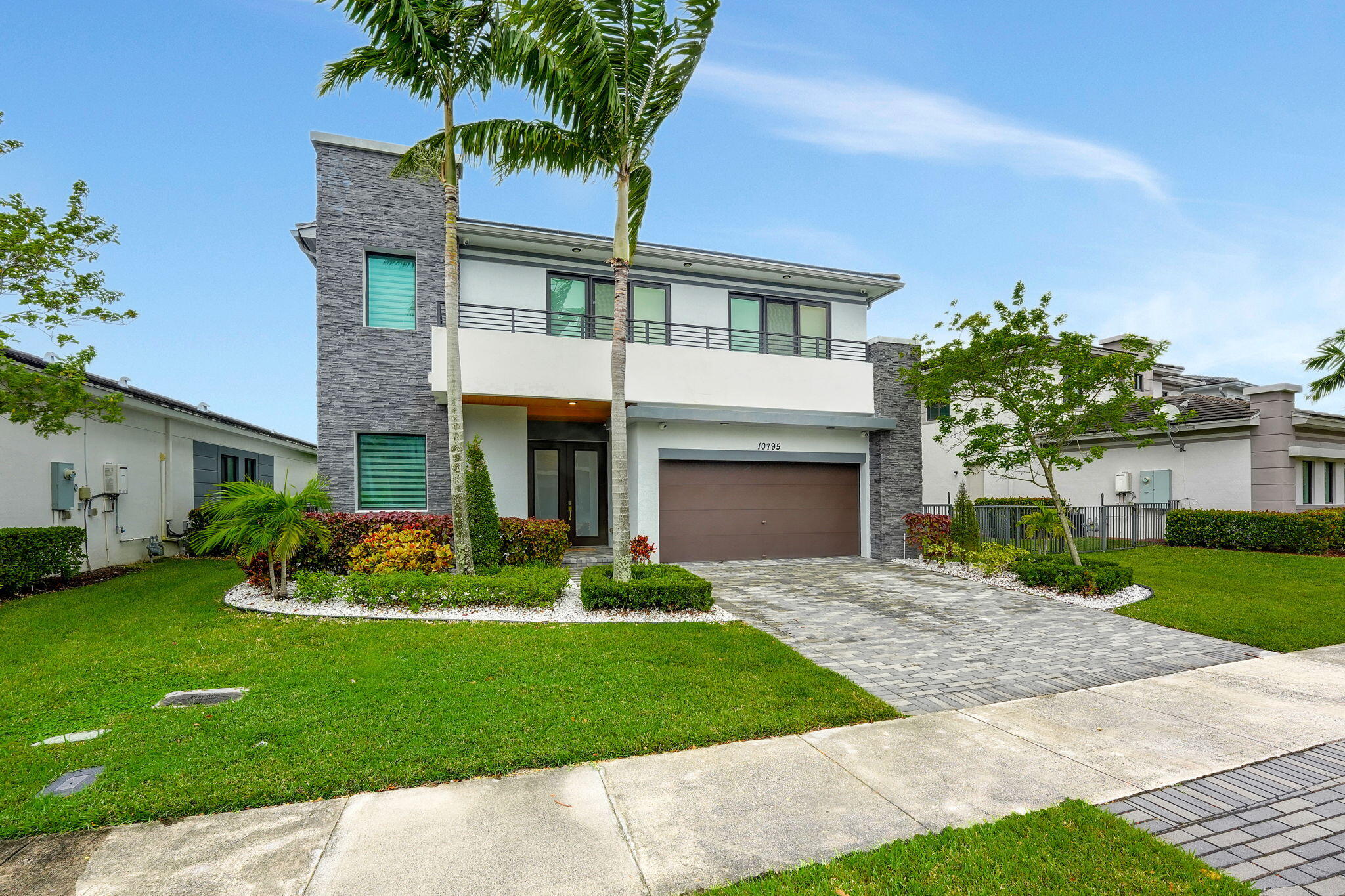 a front view of a house with a garden and plants