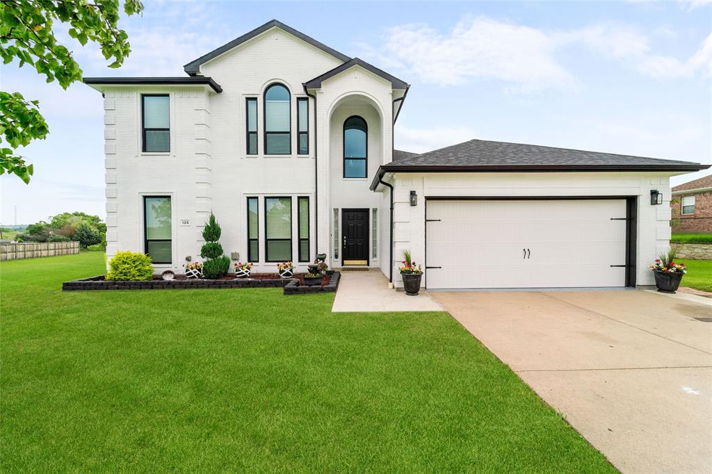 a front view of a house with yard and green space