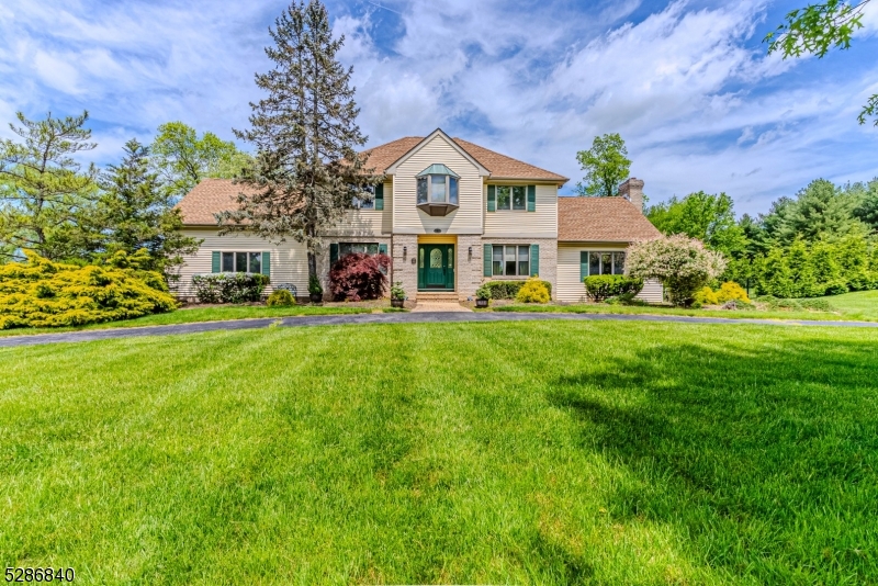 a front view of a house with garden and trees