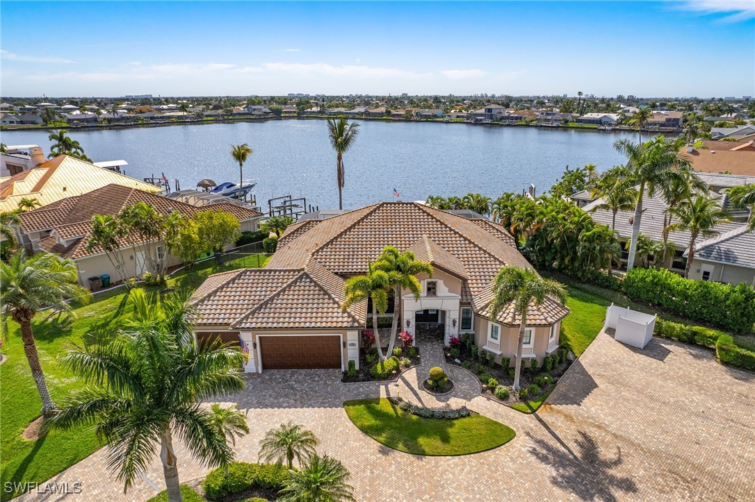 an aerial view of a house with a garden and lake view