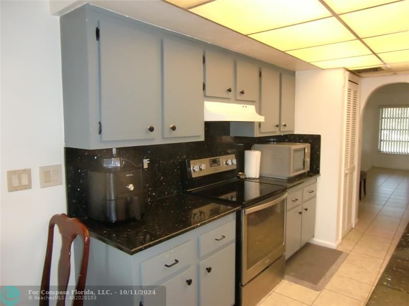 a kitchen with stainless steel appliances granite countertop a sink a stove and a refrigerator