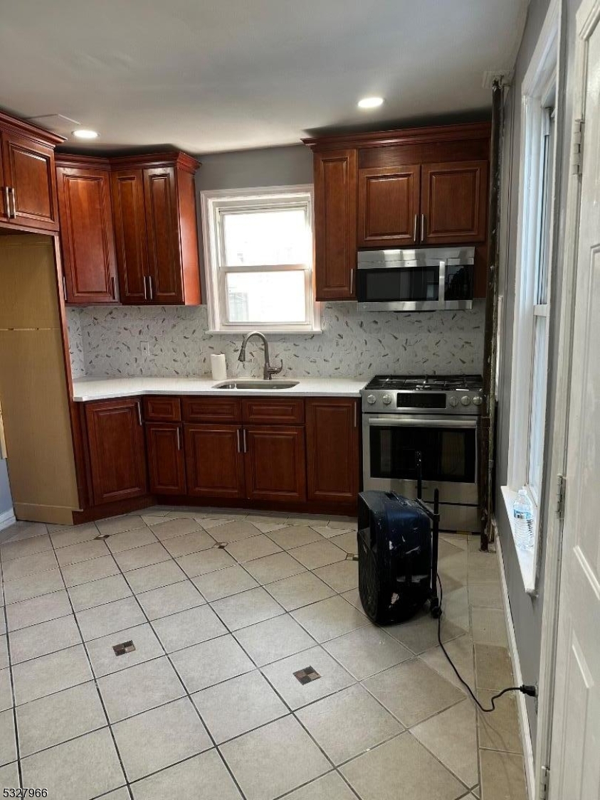 a kitchen with stainless steel appliances granite countertop a stove sink and cabinets