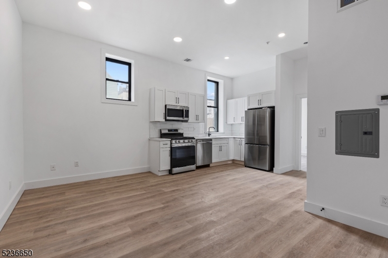 a kitchen with stainless steel appliances a refrigerator and a stove top oven