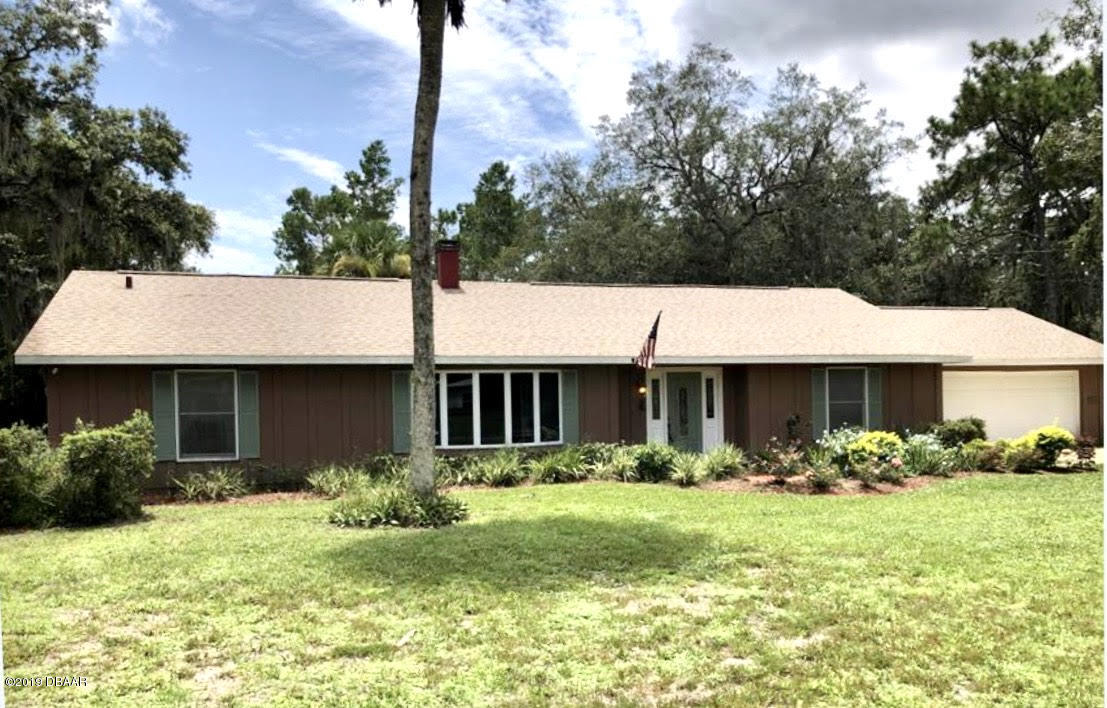 a front view of house with yard and trees