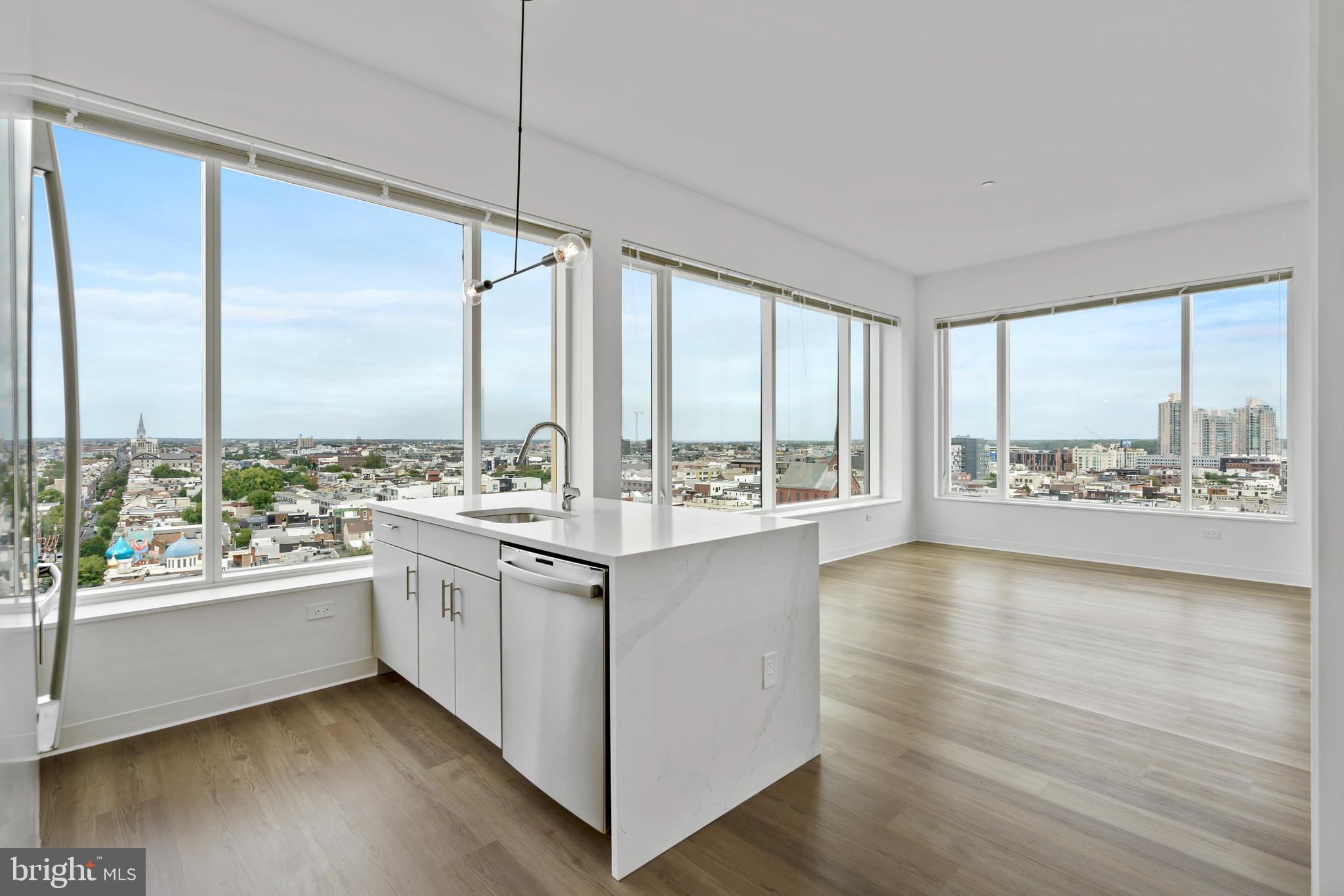 a kitchen with a large window and wooden floor