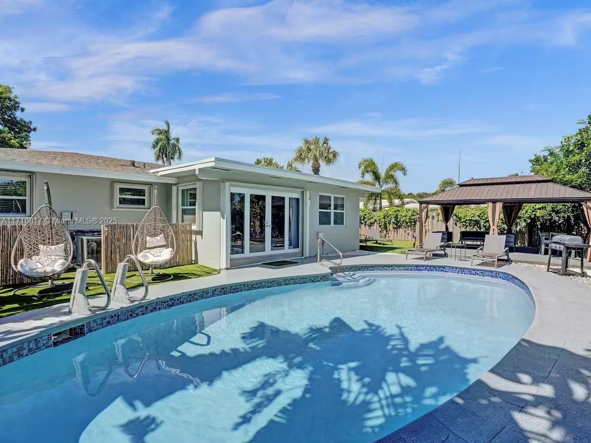 a view of a house with swimming pool and sitting area