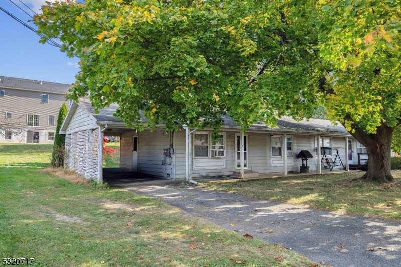 a front view of a house with a yard and trees