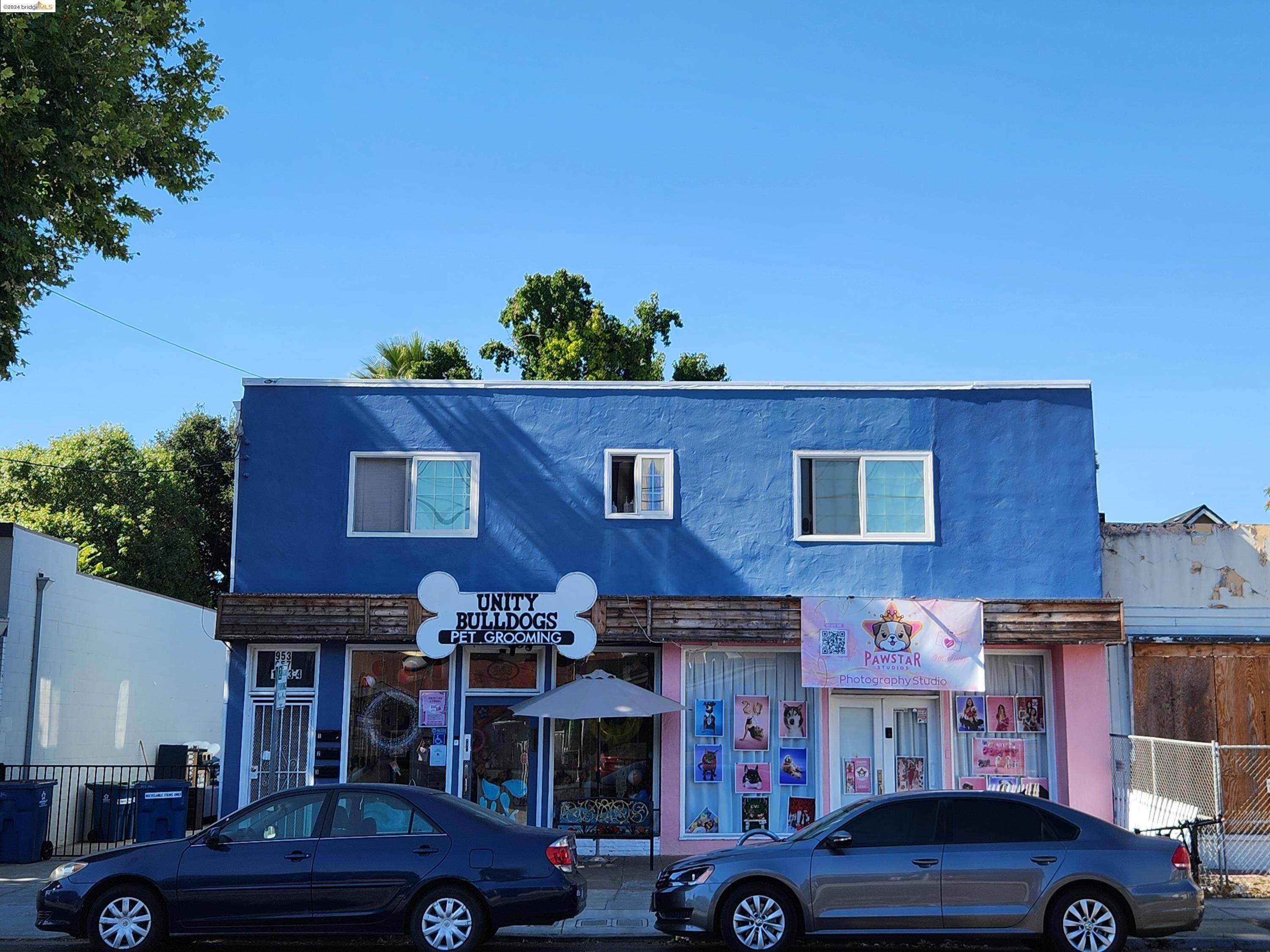 a front view of a building with cars parked