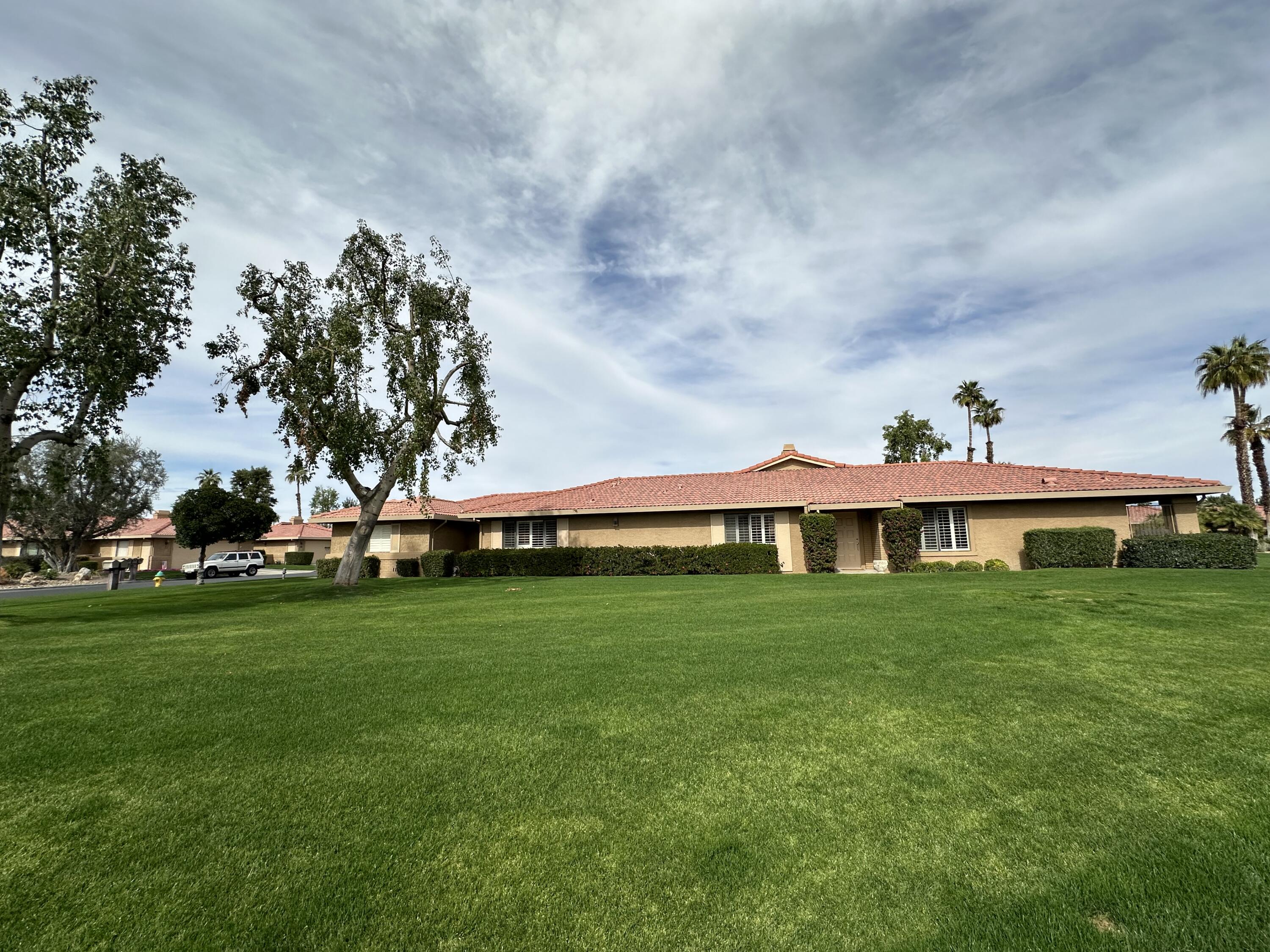 a view of a big yard with a house in the background