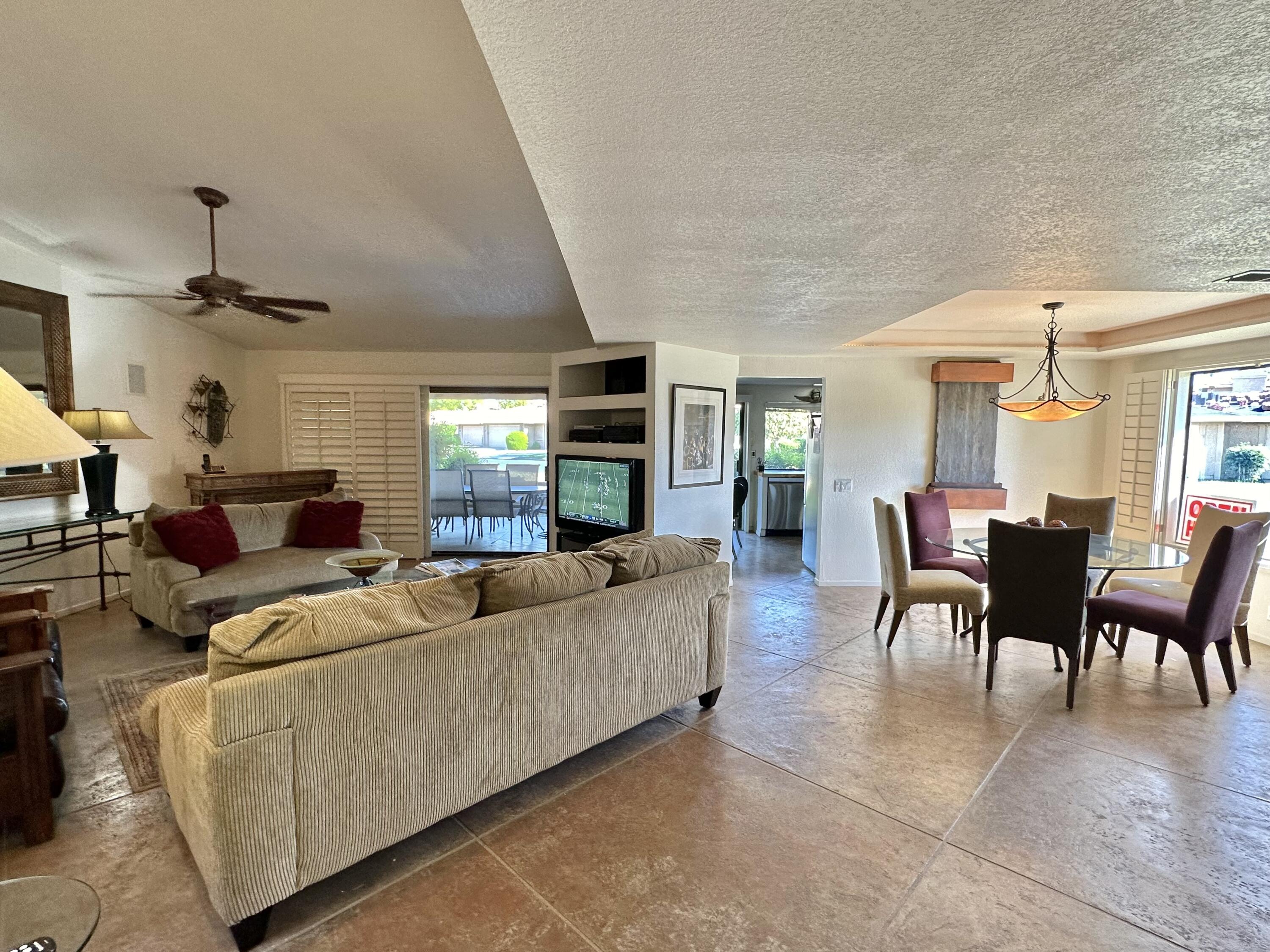 a living room with furniture and a dining table with kitchen view