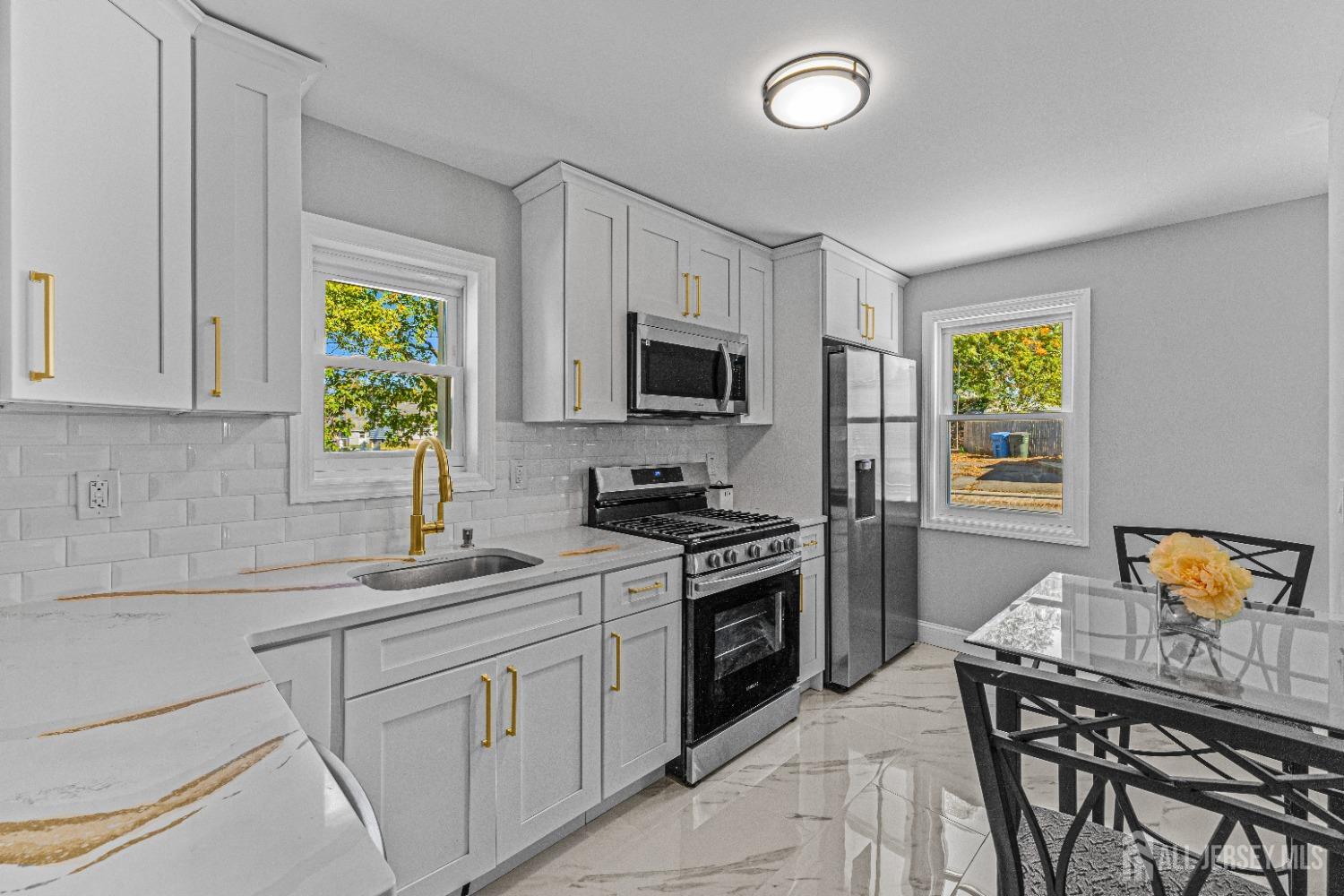 a kitchen with stainless steel appliances granite countertop a stove a sink and a microwave