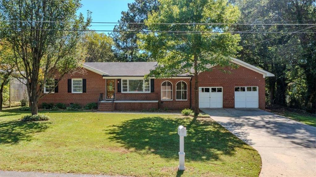 a front view of a house with a yard and trees