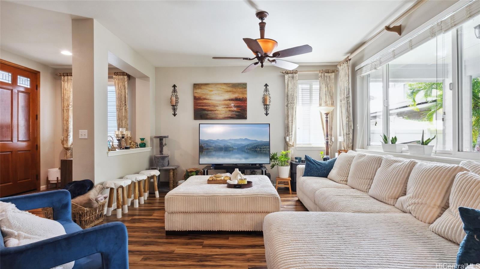 a living room with furniture ceiling fan and a window