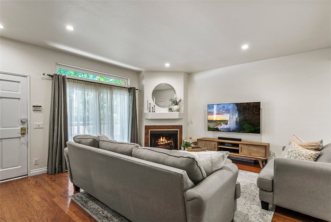 a living room with furniture a fireplace and a flat screen tv