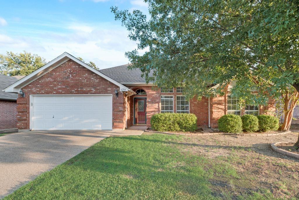 a front view of a house with a yard and a garage