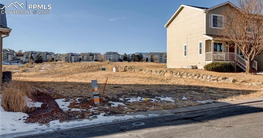 a view of a dry yard with wooden fence