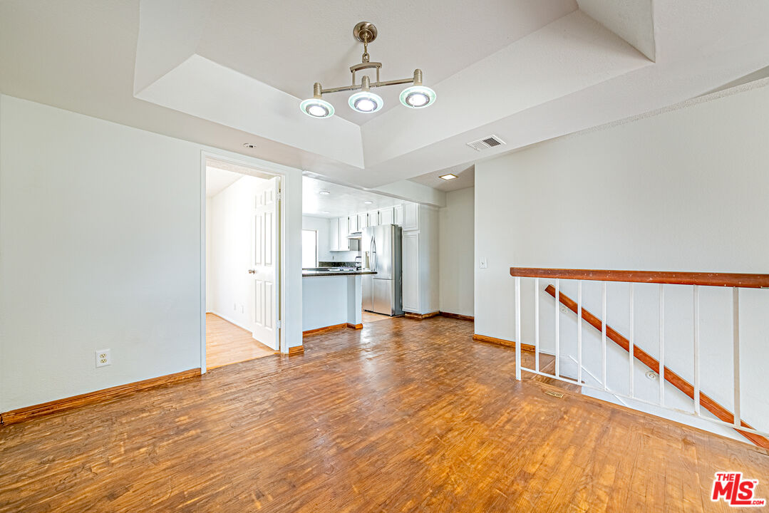 a view of a kitchen with wooden floor and an entryway