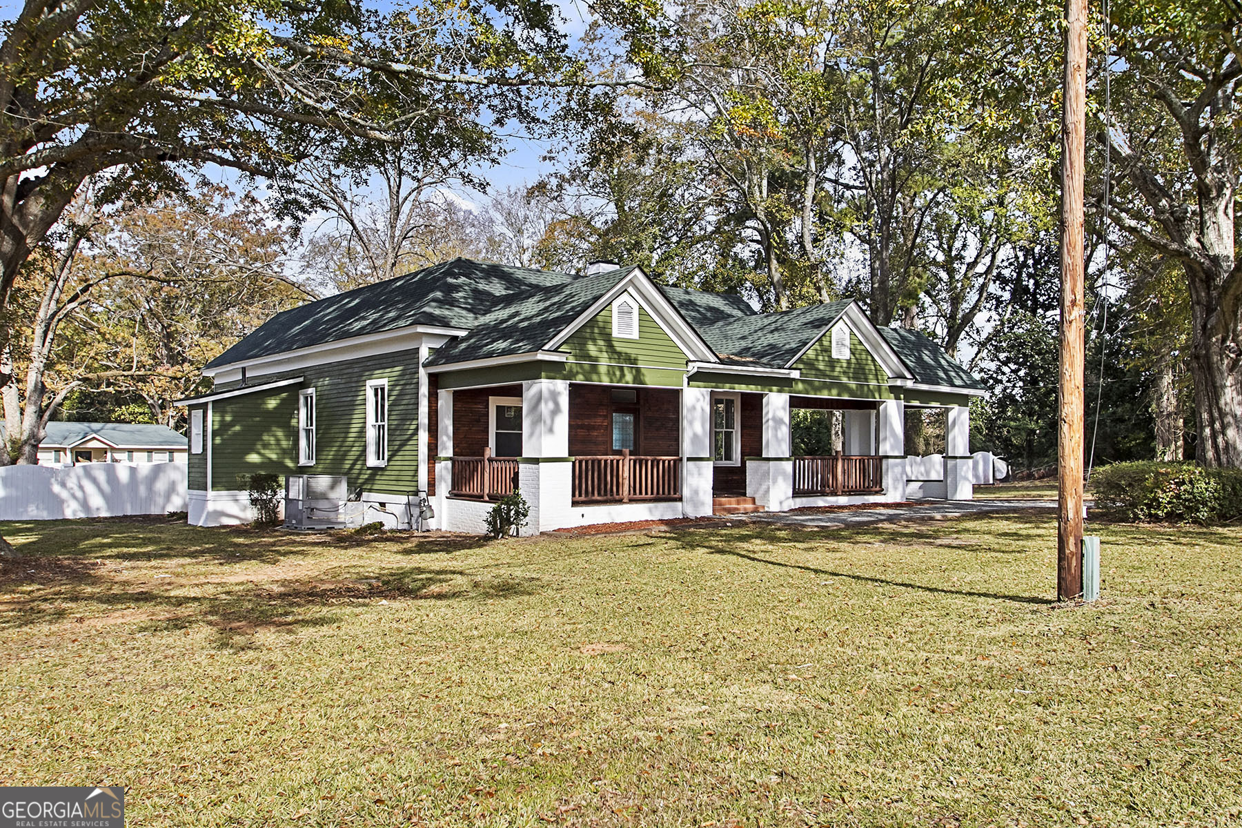 a front view of a house with swimming pool and porch with furniture