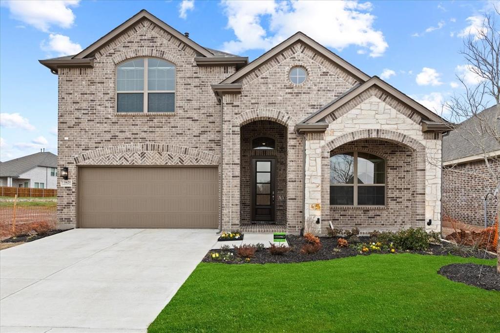 a front view of a house with a yard and garage