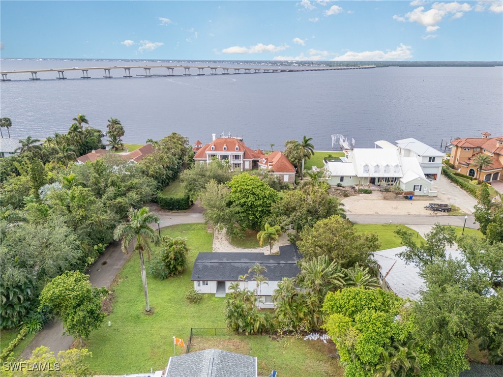 an aerial view of a house with a yard and lake view