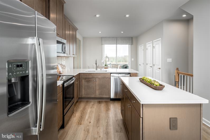 a kitchen with a sink a counter top space stainless steel appliances and cabinets