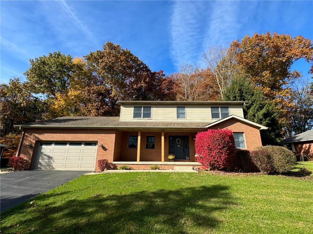 a front view of a house with a garden and yard