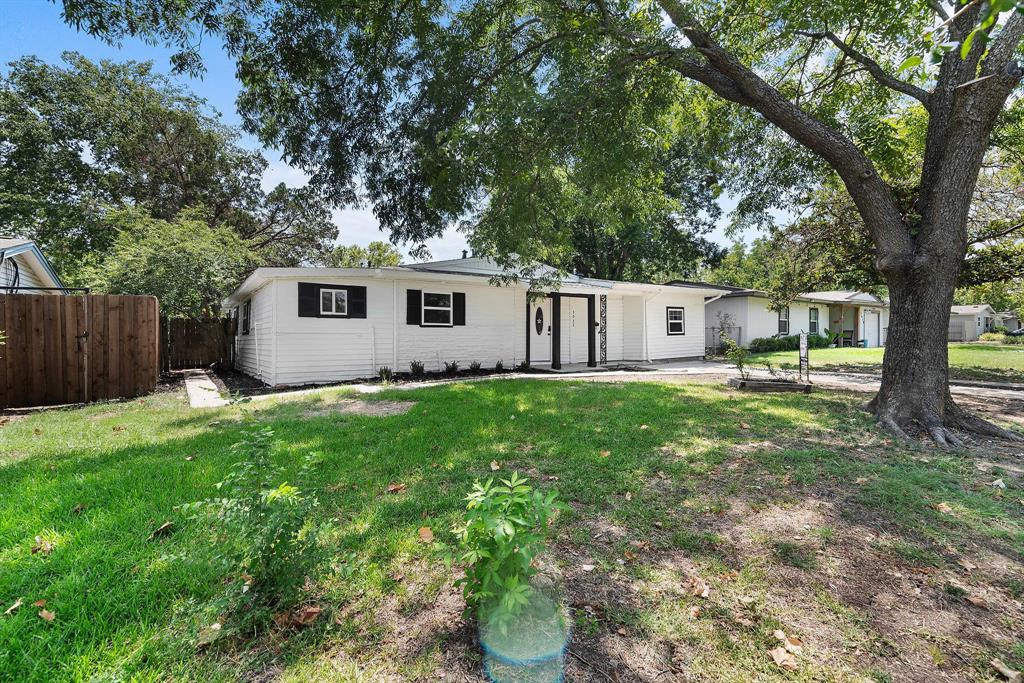 a view of a house with backyard and a tree