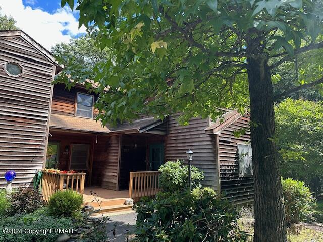 a view of a house with a small yard and a large tree