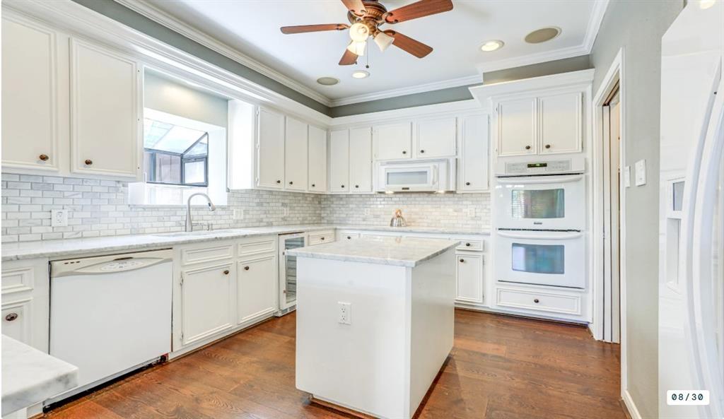 a kitchen with granite countertop white cabinets and white appliances