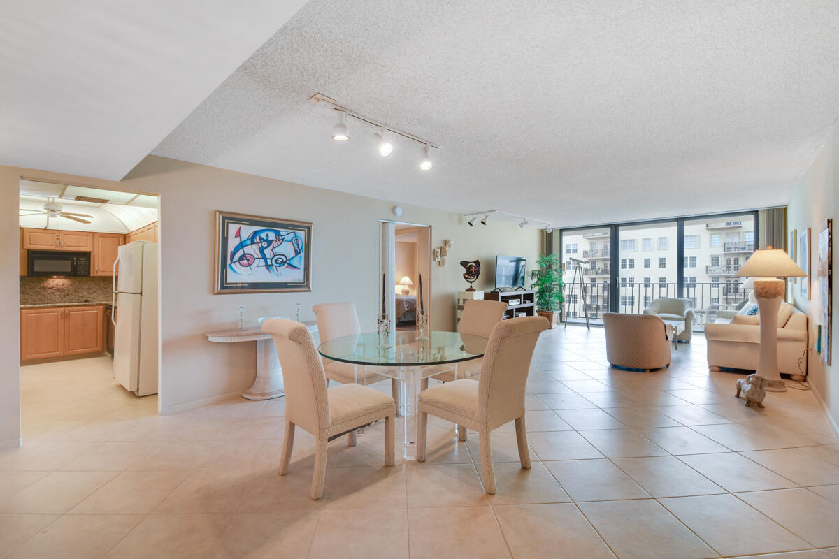 a dining room with furniture and a floor to ceiling window